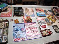 Overview of vintage posters, postcards, magazines, and collectibles spread on a table