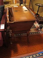 Side view of wooden side table showing flip-up top opened and storage compartment inside
