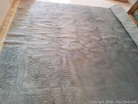 Angled full view of rug with rolled end