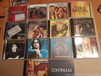 Photo showing 14 CDs arranged, including The Best of Santana, Lynyrd Skynyrd Gold, The Who, Doobie Brothers Live, Doors, Lou Reed Transformer, James Taylor, Janis Joplin, Steve Miller Band, Van Morrison Continuum, and others