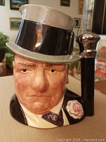 Front view showing detailed facial features, top hat, and flower lapel.