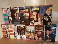 Front view of the 11 classic VHS movies arranged standing upright on a shelf, showing cover art and titles.