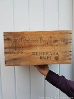 Front of wooden crate displaying Hudson's Bay Company crest, incorporation date, and 'Demerara Rum' text.