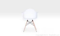 Front view of a white Eames style chair with wood legs showing seat and armrest design.
