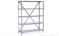 Tall antique industrial style metal bookshelf with dark grey/black patina, cross-brace back, and caster wheels, photographed front angle.