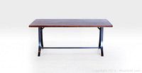 Front view of walnut wood top dining table with steel legs on a white background.