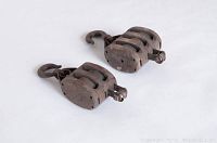 Pair of vintage wooden double pulley blocks laid flat showing top metal hooks and wooden frame.