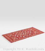 Front angle view of the rectangular red area rug showing geometric and floral pattern and fringed edges.