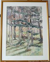 Full view of the framed watercolor painting showing conifer trees and a bridge in the background.