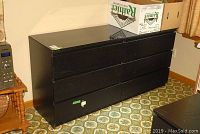 Full front and side views of the black brown IKEA Malm dresser showing six drawers and scratched top finish.