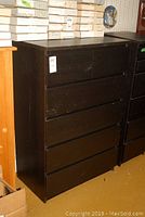 Full view of 6 drawer IKEA Malm dresser in black brown color, showing front and side with visible scratches and scuffs.