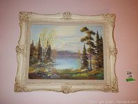Front view of the framed oil painting showing the landscape scene of a lake, trees, and mountains.