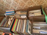 Six boxes filled with assorted LP vinyl records sorted by various artists and genres.
