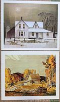 Two prints stacked vertically: top print shows a large white house with snow, bottom print shows a rustic cabin with autumn trees.