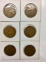 Six George VI pennies individually packaged in white cardboard coin holders with clear windows showing the coin fronts.