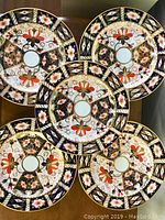 Five plates arranged on table showing overall Imari-style pattern.