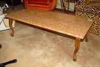 Full view of rectangular coffee table with walnut finish wood legs and frame, stone marbled top showing surface pattern and edge detail.