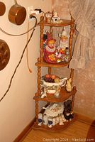 Full view of the four-tier wooden corner shelf with clown figures on top shelves, faux fruit bowl, and soup tureens on lower shelves.