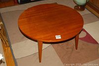 Round walnut finish wood coffee table from a top angle.