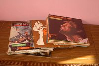 Stack of vinyl record albums spread out showing front covers, including Glen Campbell Live album and others