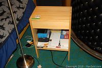 Front view of pine wood shelf showing central drawer and open bottom shelf with papers and boxes present (contents not included).