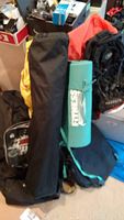 Photo showing packed camping gear including black backpack, yellow backpack, some carrying bags and camping equipment stacked together