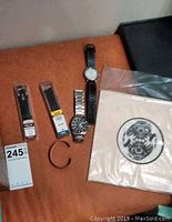 Overview of watches, watch bands, metal bracelet and Native art print on orange fabric