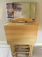 Four wooden TV trays with stand in natural wood finish