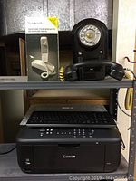 Canon MX452 printer below two wall-mounted phones, Beaumark phone box on left