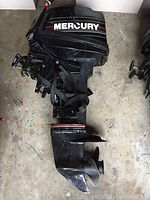 Full view of black Mercury outboard motor showing cowling, tilt bracket and lower unit with propeller.