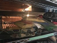 Shelves holding camping gear including folded camping chairs and blankets