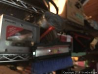 Metal shelf with cleaning brushes and portable AC adapter visible.