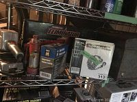 Photo of power inverter box, hydraulic jack, tow chain, and chain hoist boxes on metal shelf