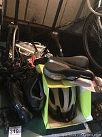 Bike seat, Shimano shoes, helmet, coiled locks and accessories shown on table.