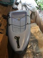 Blue canoe middle section with straps and clamps, showing connection points for assembly.