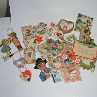 Top view of entire lot showing varied vintage die cut Valentines with children, animals, hearts, and flower motifs.