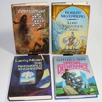 Four hardcover books with dust jackets arranged upright and flat to show front covers with titles and authors.