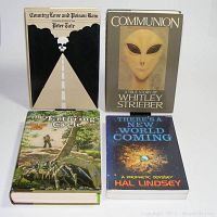 Four science fiction and fantasy books arranged on white surface showing front covers: 'Country Love and Prison Rain' by Peter Tate, 'Communion' by Whitley Strieber, 'The Erthring Cycle' by Wayland Drew, and 'There's a New World Coming' by Hal Lindsey.