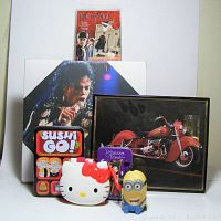 Shows entire lot including Michael Jackson print, Harry Potter stickers, Hello Kitty compact, Minion figure, Sushi Go card game tin, and Vanessa Tarot cards tin.