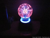 Plasma light on in dark setting showing colorful plasma streams inside the globe.