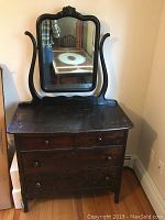 First bureau with a swivel mirror and four drawers, showing wear and antique style.