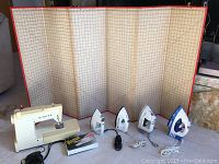 Full lot including the Singer electric sewing machine, four electric irons, and sewing measuring board with grid.