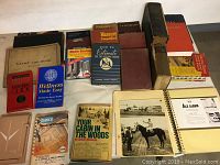 Photo showing a collection of assorted hardcover and paperback books including Bibles, dictionary, self help, wellness, and other manuals.