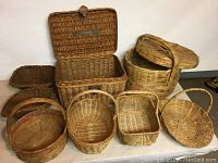Photo of eight woven baskets of different sizes, some with handles, some with lids.