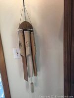 Bamboo wind chime hanging indoors with natural bamboo tubes and wood top