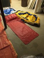 Inflatable mats and raft laid on floor showing condition and color variety
