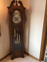 Full front view of the tall wooden grandfather clock