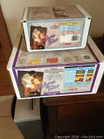 Two boxed Warm Tiles insulated heating wire floor warming kits stacked on a surface. Boxes show product branding, installation images, and technical information.