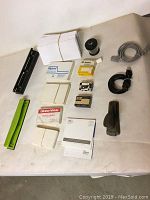Overview of miscellaneous office supplies showing envelopes, index cards, paper punches, tape, stapler, cords and hardware tool.