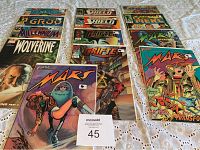 Three rows of comic books arranged on a surface, showing covers of titles including Wolverine, Grifter, Mars and Nick Fury with vibrant cover art.